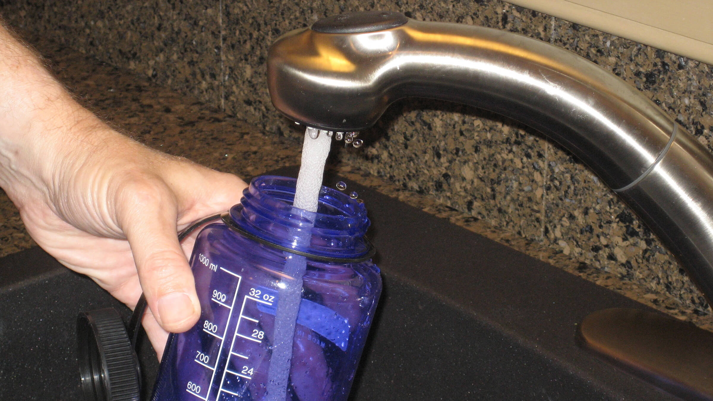 Image of water bottled begin filled with water. 